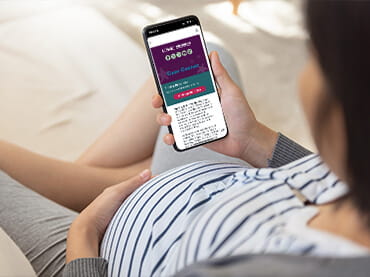 Pregnant woman looking at her cell phone