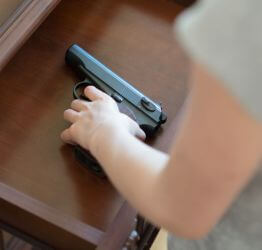 Person putting a gun in a drawer