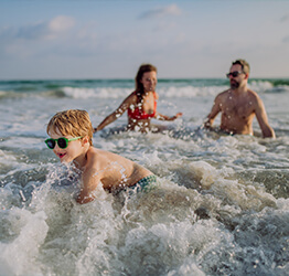 A family playing in the ocean together after a wave