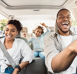 Family in a car smiling together